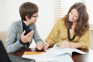 Businesswoman reviewing paperwork with woman